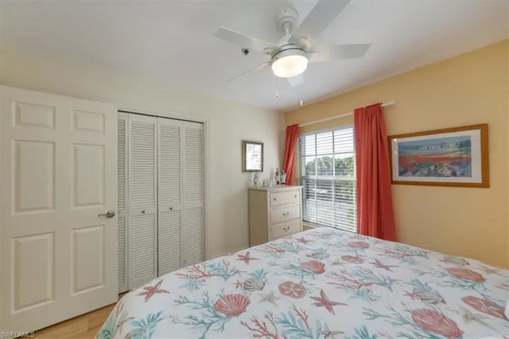 Bedroom with a ceiling fan, light wood-style floors, and a closet