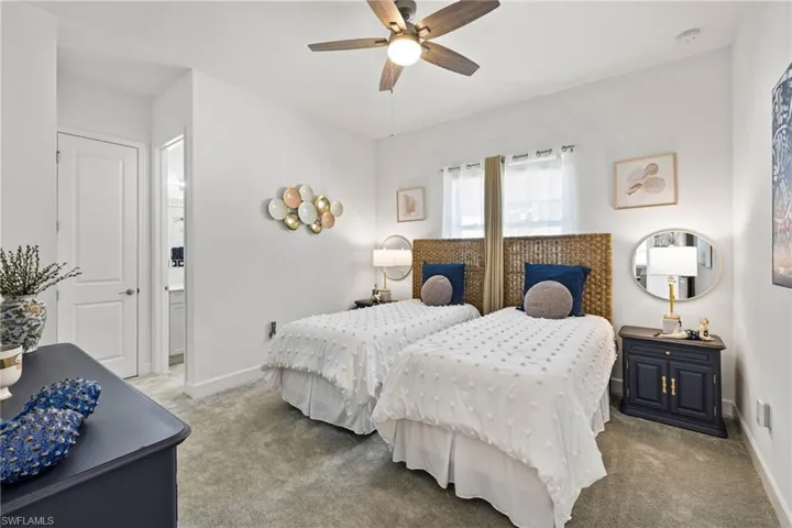 Guest bedroom 1 featuring ensuite bathroom and a ceiling fan