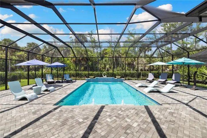 Outdoor pool with a lanai, a patio area, and a sunroom