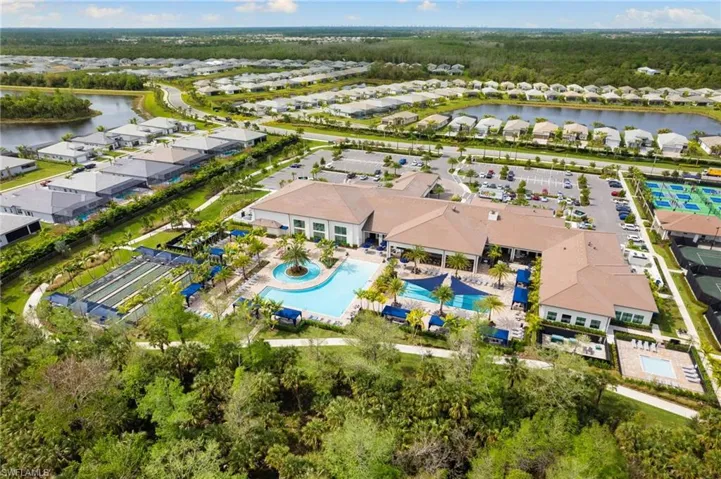 Aerial view of residential area with a nearby body of water and a pool area
