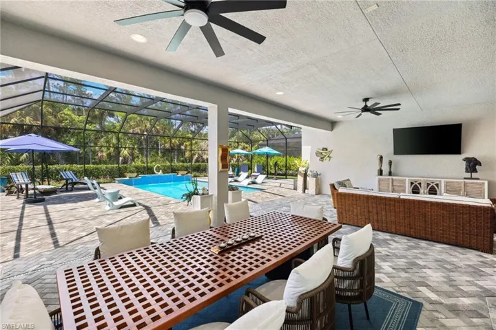 View of patio / terrace with a ceiling fan, an outdoor living / dining area, glass enclosure, and an outdoor pool