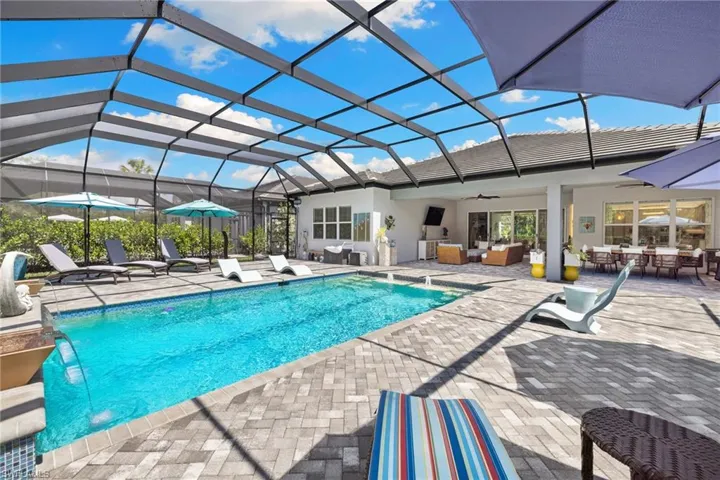 Swimming pool with a lanai, a sunroom, a patio area, and an outdoor living / dining area