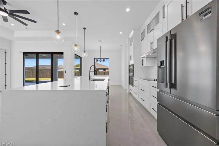 Kitchen featuring ceiling fan, recessed lighting, a large island with sink, stainless steel appliances, and a sink