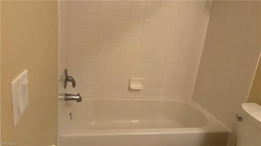 Tub and shower combination with white tile surround and chrome fixtures