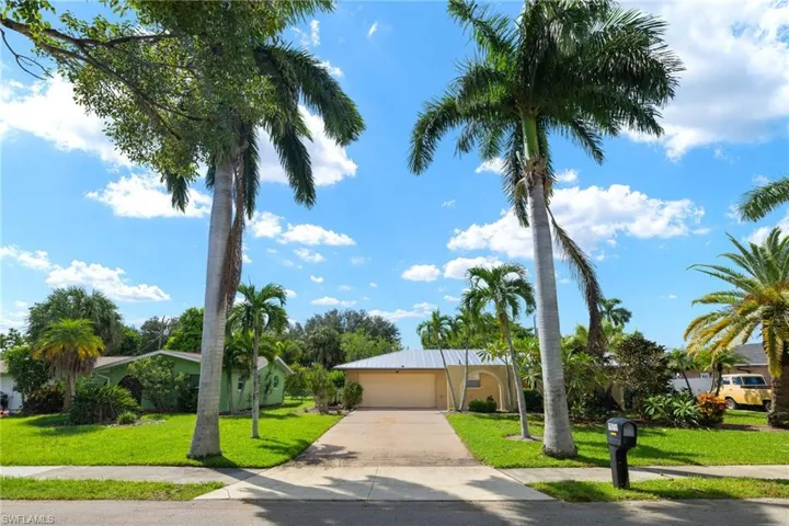 View of front facade featuring a garage and a front lawn