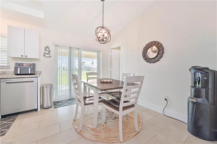 Dining area featuring lofted ceiling, a chandelier, and light tile patterned flooring