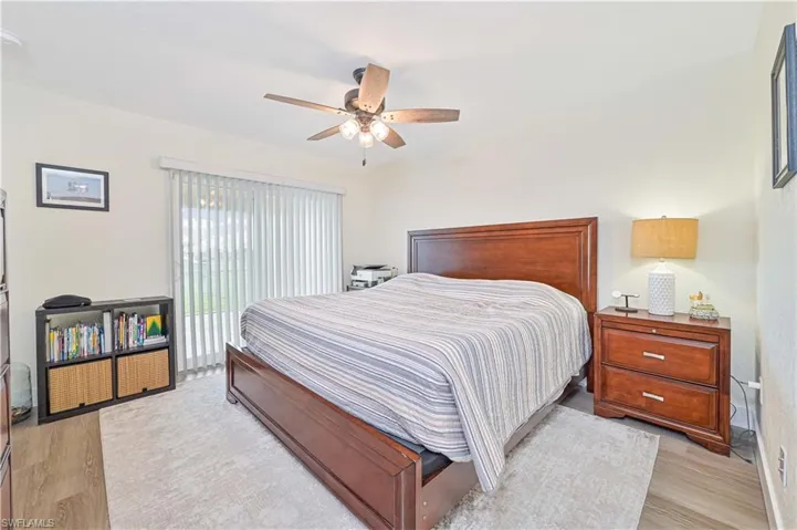 Bedroom with light wood-type flooring, access to exterior, and ceiling fan