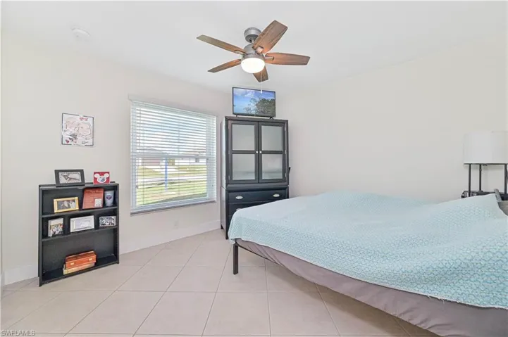 Bedroom with light tile patterned flooring and a ceiling fan