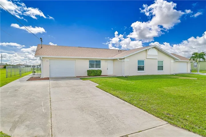 Ranch-style house featuring an attached garage, concrete driveway, and stucco siding