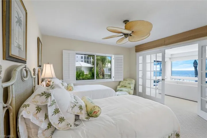 Carpeted bedroom featuring french doors and a ceiling fan