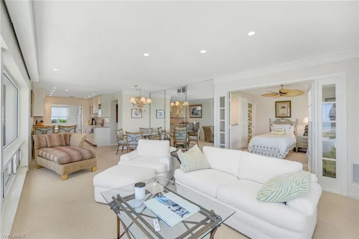 Carpeted living area with recessed lighting, ornamental molding, a chandelier, and ceiling fan
