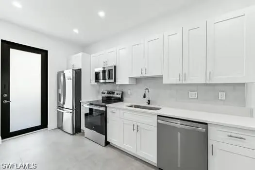 Kitchen#1 featuring stainless steel appliances, white cabinets, light countertops, recessed lighting, and backsplash