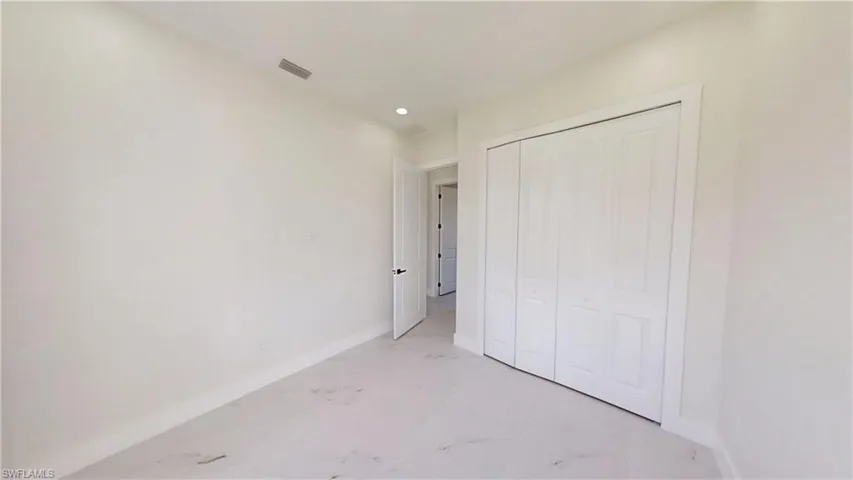 Unfurnished bedroom with light marble finish flooring and a closet