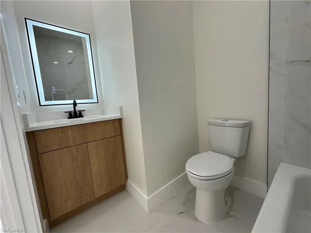 Bathroom with light marble finish floors and shower / washtub combination