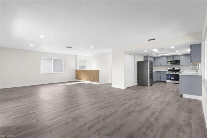 Unfurnished living room with recessed lighting and dark wood finished floors