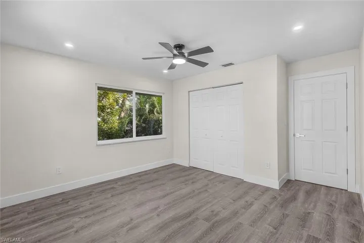 Unfurnished bedroom with a closet, wood finished floors, a ceiling fan, and recessed lighting
