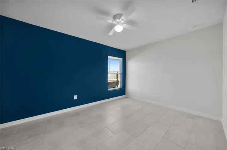 Spare room with ceiling fan and baseboards