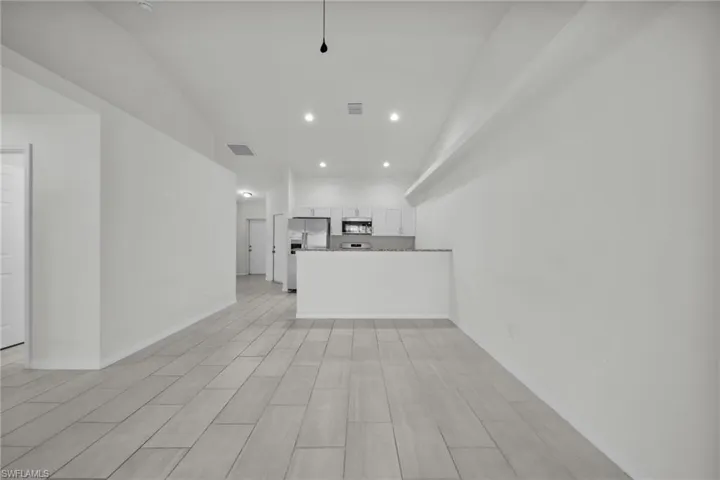 Unfurnished living room with recessed lighting and wood tiled floors
