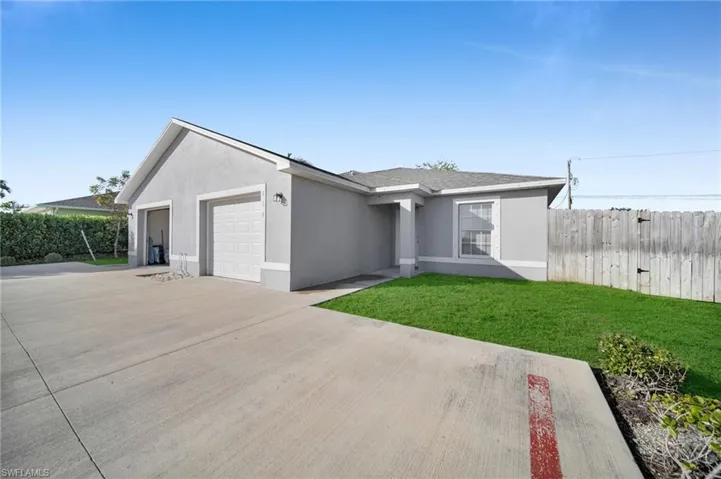 Ranch-style home featuring stucco siding, driveway, a garage, and roof with shingles