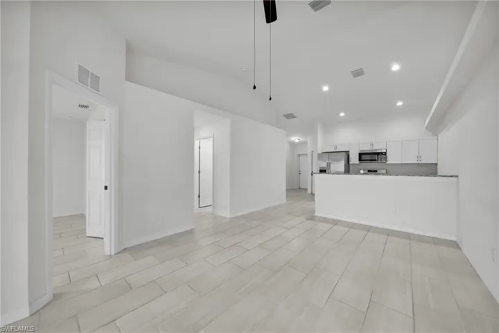 Unfurnished living room featuring recessed lighting, ceiling fan, and lofted ceiling