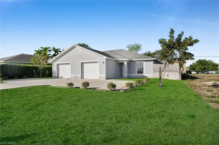 Ranch-style home featuring concrete driveway, stucco siding, and a garage
