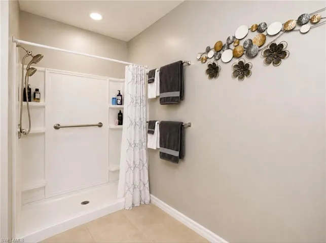 Walk-in shower wiith dual shower heads, and an accessible grab bar