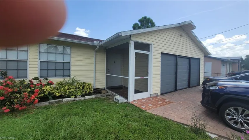 View of side of home with a garage and a sunroom