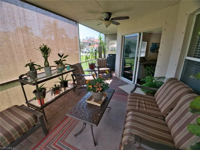 Sunroom with ceiling fan and a patio