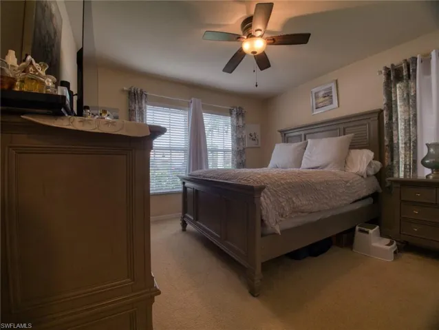 Bedroom featuring light colored carpet and a ceiling fan
