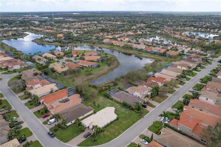 Aerial view of property and surrounding area featuring a large body of water and nearby suburban area