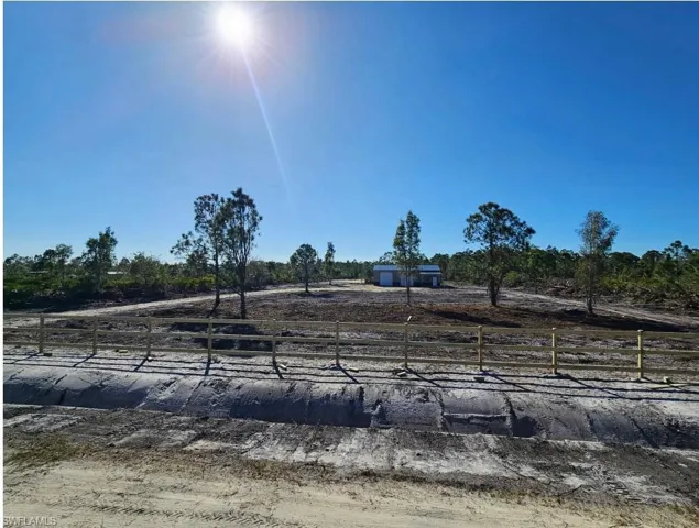 View of yard with fence and a rural view