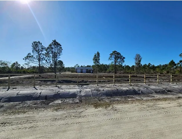 View of yard featuring a rural view and fence