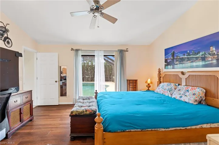 Bedroom with access to exterior, ceiling fan, dark hardwood / wood-style flooring, and lofted ceiling