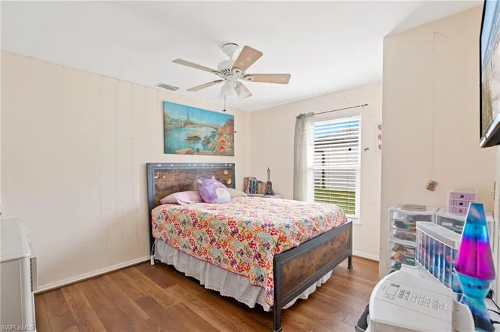 Bedroom with ceiling fan and hardwood / wood-style flooring