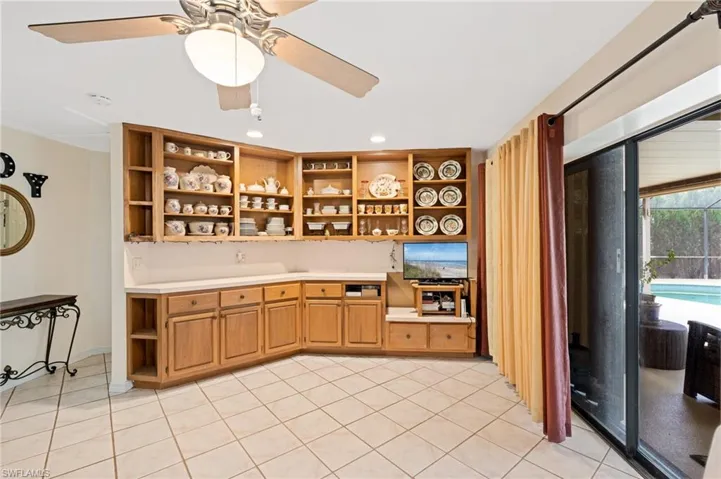 Bar with ceiling fan and light tile patterned floors