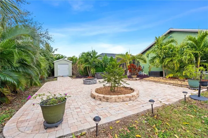 View of patio / terrace featuring an outdoor fire pit and a storage shed
