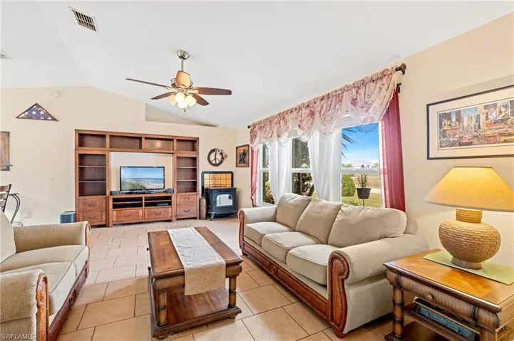 Tiled living room with vaulted ceiling and ceiling fan