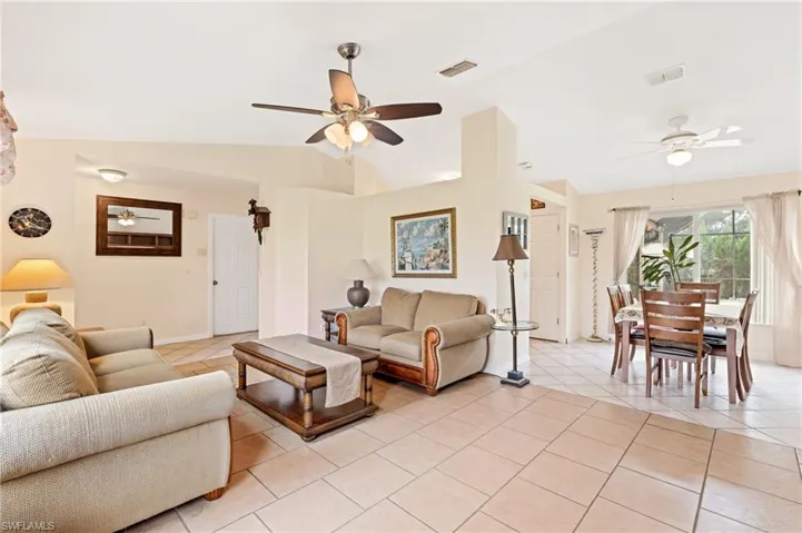 Tiled living room with vaulted ceiling and ceiling fan