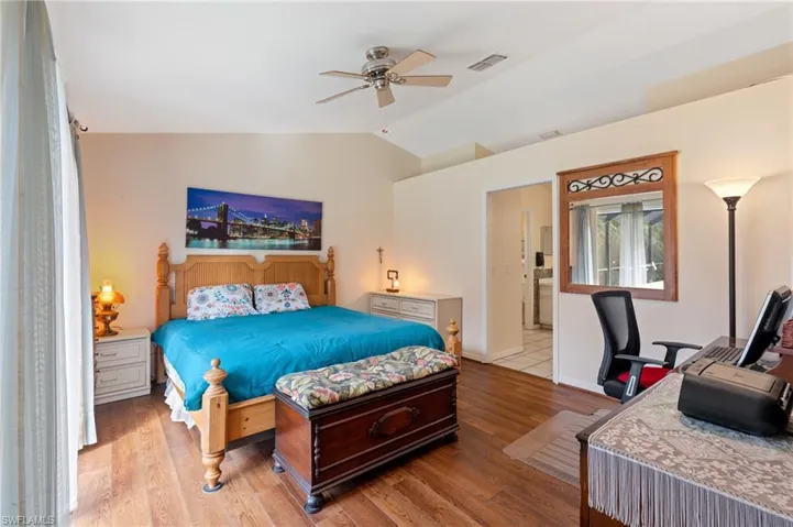Bedroom with ceiling fan, light hardwood / wood-style flooring, and vaulted ceiling
