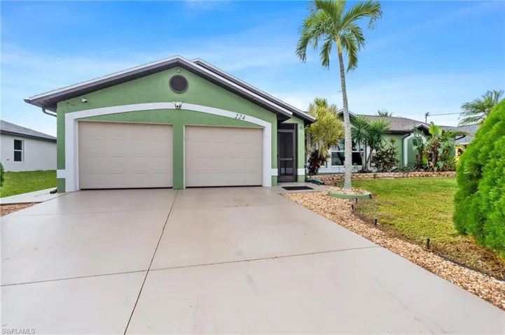 Ranch-style home with a garage and a front lawn