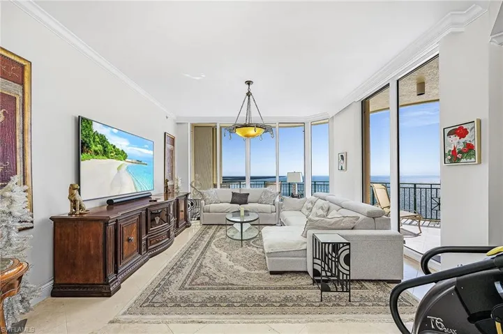 Living room featuring expansive windows and ornamental molding
