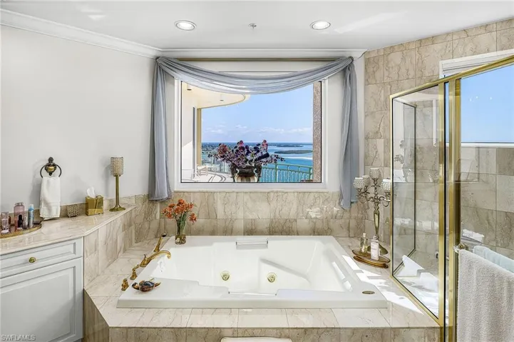 Bathroom featuring a whirlpool tub, a water view, and crown molding