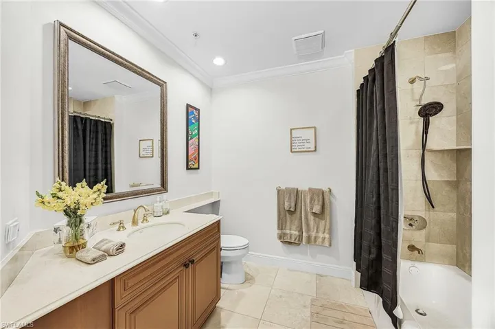 Bathroom featuring crown molding, vanity, shower / bath combo, light tile patterned flooring, and recessed lighting