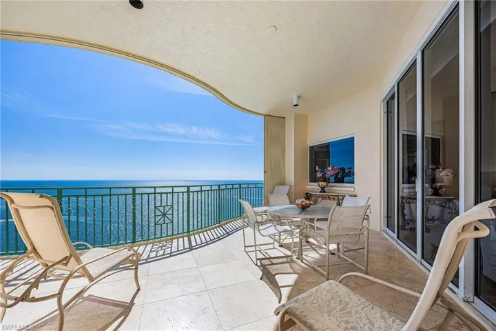 Balcony featuring a water view and outdoor dining area