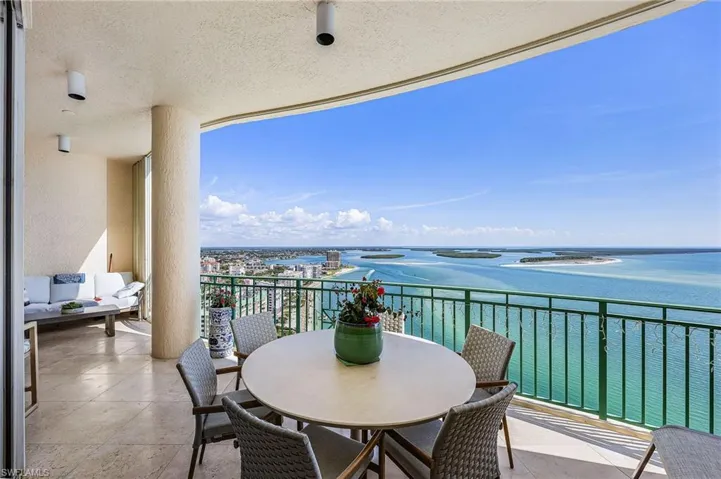 Balcony featuring a water view and outdoor dining area