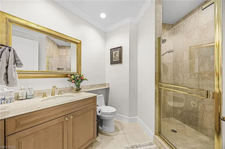 Full bathroom featuring vanity, a shower stall, ornamental molding, light tile patterned floors, and recessed lighting