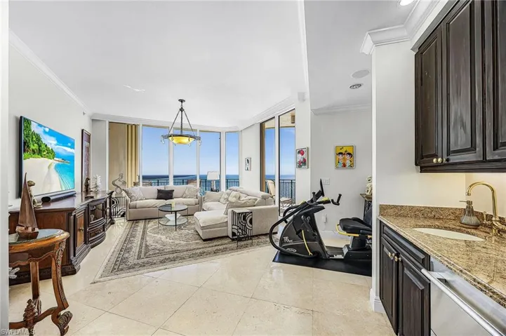 Living area featuring expansive windows, crown molding, and a water view