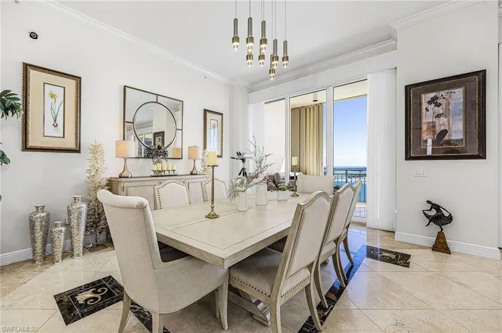 Dining room with crown molding and a chandelier