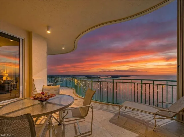 Balcony featuring outdoor dining area and a water view