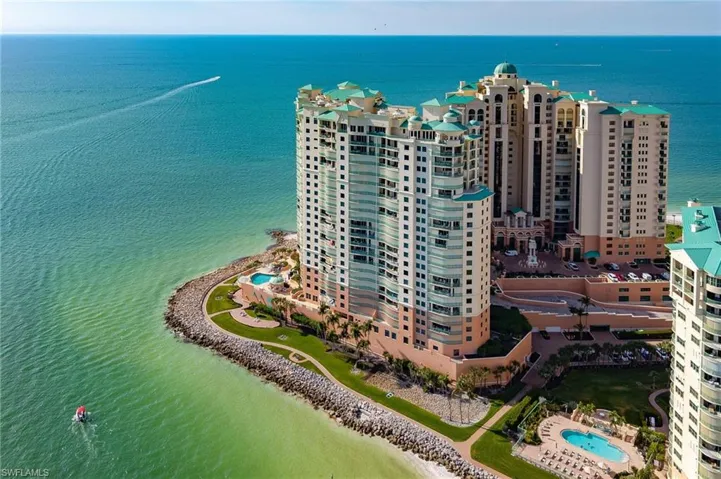 Drone / aerial view of a nearby body of water and a pool area